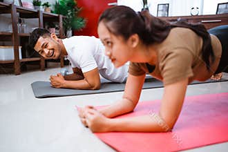 fitness couple planking together. man and woman exercising at home