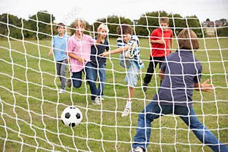 Boys playing soccer in park