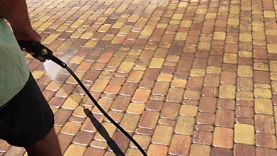 Cleaning backyard paving tiles with high pressure washer. Spring clean up. Cleaning dirty backyard paving tiles with