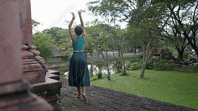 Back View Of A Happy Woman Tourist Wearing Halter Top And Flared Skirt, Doing A Ballet Dance Outside The Old Temple In