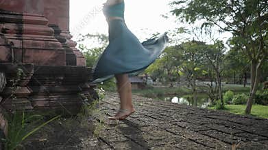 A Woman In Blue Clothing Gracefully Twirling In The Cobblestone Pathway Within The Ancient Siam Museum, Thai Ban Mai