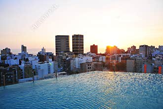 hotel pool, at sunset city and buildings with modern apartments and offices illumination marriott sunset