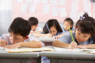 Students Working At Desks In Chinese School