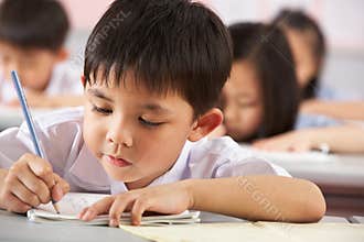 Students Working At Desks In Chinese School