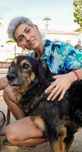a non-binary person with a funky shirt and their dog looking at camera