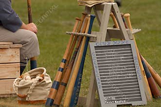 Set of old-time baseball equipment with bats, balls, and the team lineup