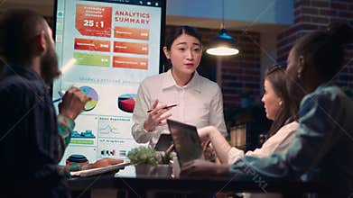 Asian business coach explaining statistics graphs visualization