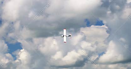 Classic light propeller planes flying in a sunny blue sky with white clouds