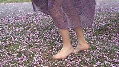 Girl is spinning on the petals with bare feet.