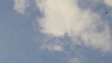 A very clear sky with white clouds covering it on a hot day