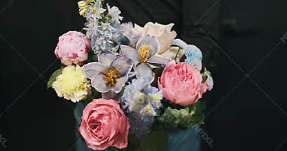 A male florist adds flowers to a beautiful arrangement