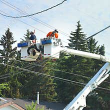 Two electricians checking electrical cables, outdoor in a small city