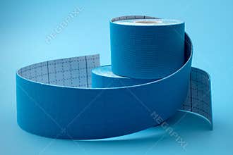 Blue Physio or Kinesiology Tape Rolls on Matching Background Concept for Supportive Athletic Care, Enhancing Physical Flexibility