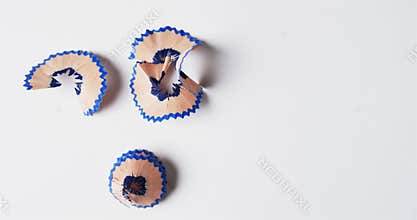 Overhead view of blue crayon shavings with copy space on white background, in slow motion