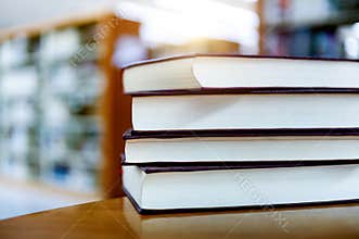 four books stacked on desk