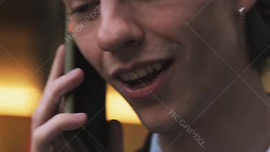 Close up shot of lower part of face of caucasian businessman in formalwear talking on mobile phone outdoors