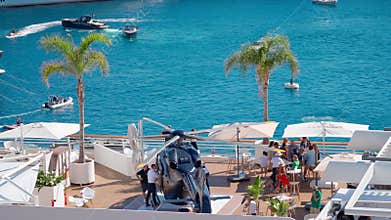 Monaco, Monte-Carlo, 29 September 2022: Rich clients visitors examine a helicopter standing on the deck of a yacht club