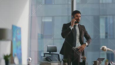 Busy lawyer talking smartphone standing at modern office. Busy manager calling.