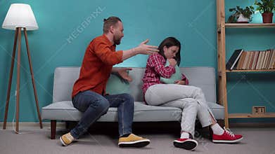 Breaking-up and divorce concept. Young married couple having fight and yelling at each other in living room at home