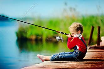 Little girl fishing from dock on lake