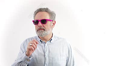 middle-aged grey-haired man looks away taking off sunglasses when looks on the left white background studio shot copy