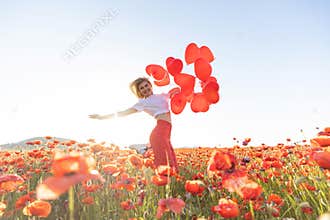 Happy woman holding balloons in nature.