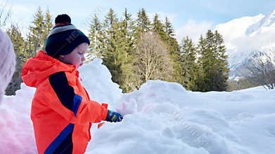 Boy play outside and throw snow with shovel having fun