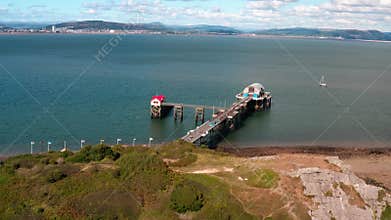 Aerial View of Mumbles Lighthouse and Pier, part of the Gower coastline in South Wales. bright blue waters on a sunny