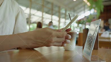 woman use smartphone to scan QR code in cafe. The restaurant built a digital payment system without cash. Qr code pay, E wallet,