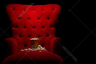 Closeup shot of popcorn on a red cinema chair in the dark - cinema concept