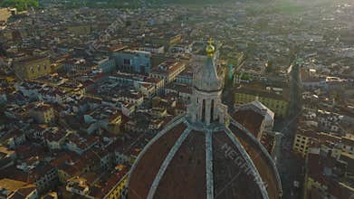 Aerial footage of old town with sights at golden hour. Backwards reveal of large cupola of Florence Cathedral with