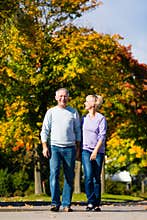 Seniors in autumn or fall walking hand in hand