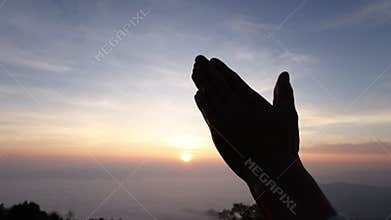 silhouette of Praying hands with faith in religion and belief in God on dark background. Power of hope or love and devotion.
