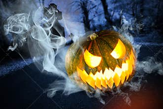 Scary halloween pumpkin on cemetery at night