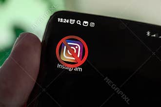 A crossed-out icon on a black smartphone screen. the concept of banning the application instagram