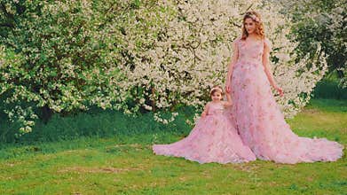 Mother woman queen with little girl daughter cute princess. Same ball gowns pink dress creative wedding design. Spring