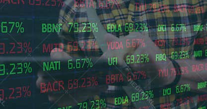 Financial analyst tapping tablet starting to scroll tickers overlaid green red data for investing