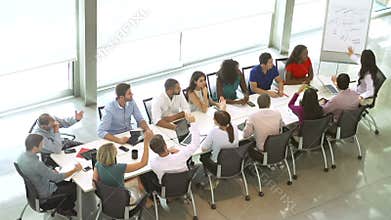 Businesswoman Addressing Meeting Around Boardroom Table