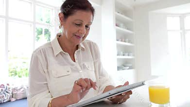 Senior Indian Woman Using Digital Tablet At Home