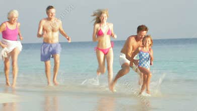 Multi Generation Family Having Fun In Sea On Beach Holiday