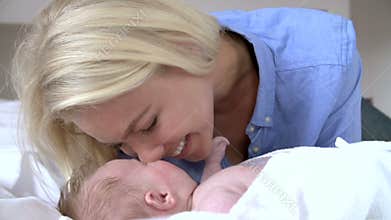 Mother Rubbing Noses With Baby In Bed