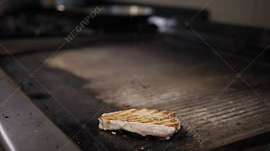 Salt Falling On Top Of The Swordfish Cooking On The Grill