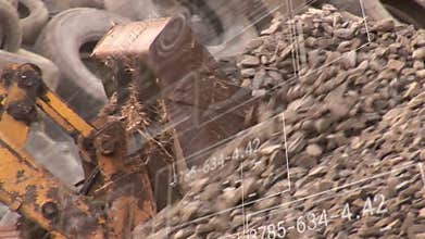 Excavator arm touching crushed stone pile, scooping gravel and dumping loads to build raised mound