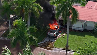 Emergency service personnel responding to car accident on Florida street. First responders extinguishing fire on burning vehicle.