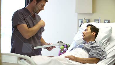 Nurse Talks To Male Patient In Hospital Room