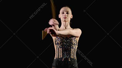 Portrait of female athlete practicing rhythmic gymnastic mills with clubs