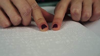 Blind woman reading text in braille language