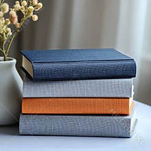 Cozy Arrangement of Stacked Books With Floral Accent in Soft Light at a Home Setting.