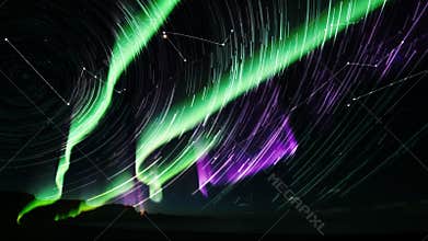 Timelapse capturing aurora sweeping over Arctic ridge, star trails spiraling to compress time