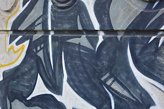 Graffiti depicting the word MAM on white, gray concrete fence.